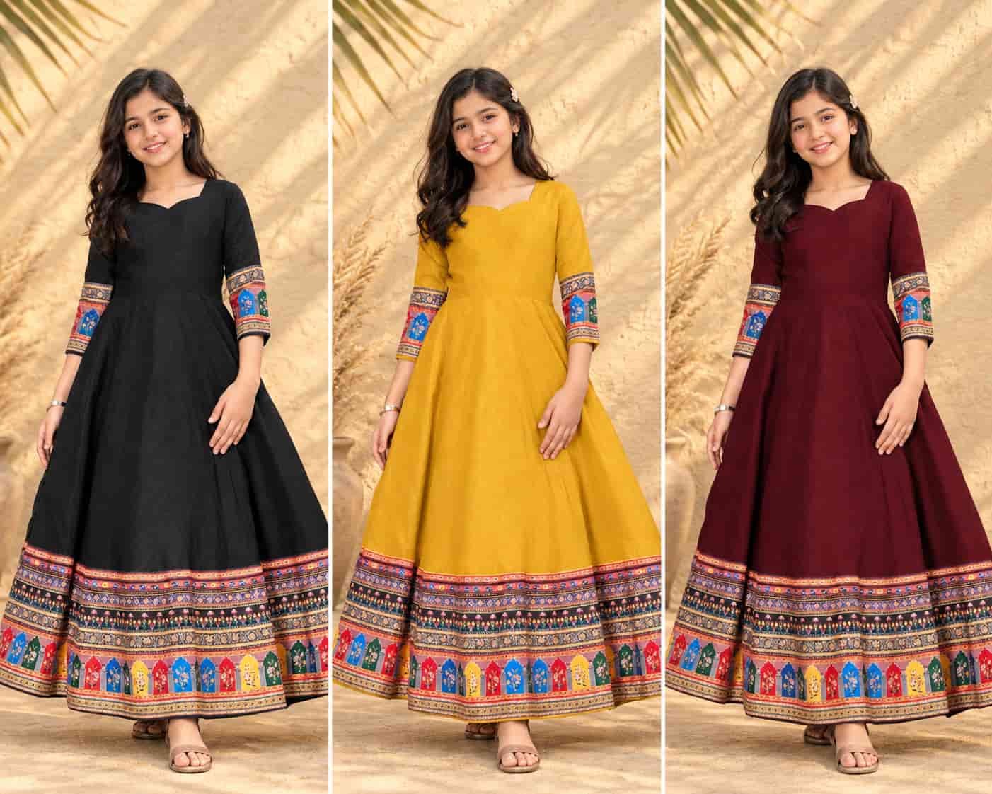 A young girl modeling a black traditional maxi dress for girls featuring vibrant ethnic printed borders.